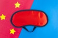 Red sleep mask on a pink blue background. Healthy sound sleep concept