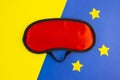 Red sleep mask on a yellow blue background. Healthy sound sleep concept