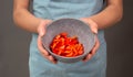 Red sliced pepper pieces in a bowl, prepare healthy food with paprika vegetables, holding fresh organic nutrition in the hands Royalty Free Stock Photo