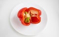 Red sliced pepper on a white plate, isolated on a white background Royalty Free Stock Photo