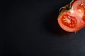 red sliced tomato on a black background