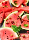 Red slices of delicious juicy watermelon with wild strawberries lying on a gray table. Royalty Free Stock Photo