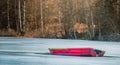 A red small boat on ice in the middle of a frozen lake Royalty Free Stock Photo