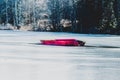 A red small boat on ice in the middle of a frozen lake Royalty Free Stock Photo