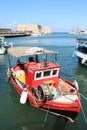 Fisherman boat anchored in harbor by fortress Koules Royalty Free Stock Photo