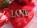 silver LOVE word, on red pillow heart, red roses. VALENTINES