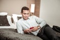 Young businessman wearing nice watch using his red smartphone