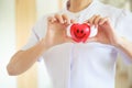 Red smiling heart held by female nurse`s both hands, representing giving effort high quality service mind to patient. Profession