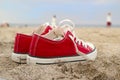 Red sneakers on sandy beach