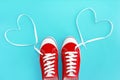 Red sneakers sport shoes with white laces and a heart pattern