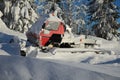 Red snowcat covered in snow on mountains Royalty Free Stock Photo