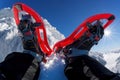 Red snowshoes against winter rocky mountains