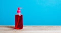 Red soap in pump bottle container over blue background