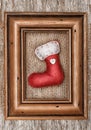 Red sock with burlap textile and wooden frame on the old wood Royalty Free Stock Photo
