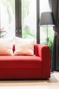 Red sofa with pillow and light lamp Royalty Free Stock Photo