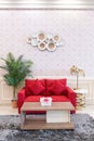 a red sofa with unique wooden table and small flower vase plus green plants and wall decoration Royalty Free Stock Photo