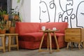 Red sofa, wooden stools, a table, and a side table with some plants as decoration Royalty Free Stock Photo