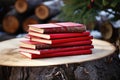 a red songbook of winter carols on a stack of firewood