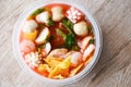 Red soup noodle pork balls crispy wontons with seafood squid shrimp and fish balls vegetable in soup bowl plastic on wooden table Royalty Free Stock Photo