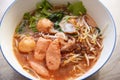 Red soup noodle pork with red roasted pork and bean sprout vegetable in soup bowl on wooden table, top view Thai and China Asian Royalty Free Stock Photo