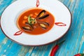 Red soup with oysters in a white plate