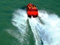 Red speed boat in closeup view. green color water. white wake Royalty Free Stock Photo