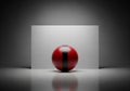 A red sphere with a black vertical stripe displayed against a light grey background. The sphere\'s Royalty Free Stock Photo