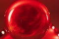 A red sphere in which is a reflection of an abstract image of reflected light