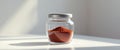 Red spice in a clear glass jar on a white surface. Royalty Free Stock Photo