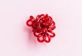 Red spiral elastic hair ties twisted. Elastic hair tie on pink background