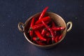 Red spisy small chili peppers in cooper bowl on dark background Royalty Free Stock Photo