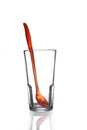 Red spoon in empty drinking glass