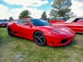 red sport Ferrari 360 Modena coupe berlinetta in a park. Nature, grass, trees. Classic car show Royalty Free Stock Photo