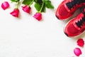 Red sport shoes and red roses on white wooden background, Valen Royalty Free Stock Photo