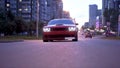 Red Sports Car Coupe Rear View In The Street. Classic powerful car in the city traffic.