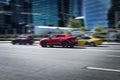 Red sports car Lamborghini Urus is driving down the street. Rear side view of fast moving SUV car on the city highway Royalty Free Stock Photo