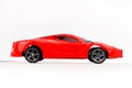 A red sports toy car on a white background stands sideways Royalty Free Stock Photo