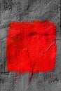 Red square with peeling paint on gray plastered wall background. Grunge texture. copy space