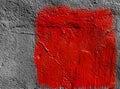 Red square with peeling paint on gray plastered wall background. Grunge texture. copy space