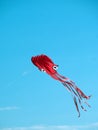 Red squid kite floating in clear sunny sky Royalty Free Stock Photo