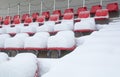 Red stadium seats covered in snow. Royalty Free Stock Photo