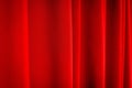 Red stage curtain with folds, fabric texture, closeup with selective focus