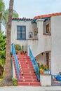 Red stairs with blue handrails at the facade of house in Long Beach California