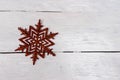Red star-shaped Christmas ornament on a white wooden surface with space for text Royalty Free Stock Photo