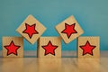 Red stars on wooden cubes on a blue background. Stars mean assessing quality. five-point rating system