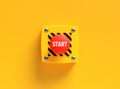 Red start button pressing on yellow background for beginning concept Royalty Free Stock Photo