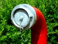 Red steel pipe fire hydrant with aluminum cap and blurred green background Royalty Free Stock Photo