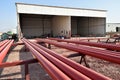 Red steel pipes for fire fighting system and extinguishing water lines in industrial building. Paint shop. Steel pipe painted red Royalty Free Stock Photo