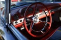 A red steering wheel in a classic American car.