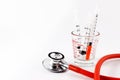 Red stethoscope with syringes in medical cup. Royalty Free Stock Photo